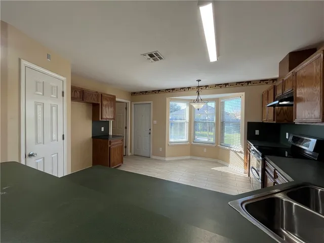 a view of a kitchen with a sink dishwasher and a refrigerator