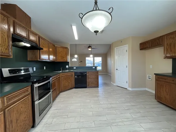 a large kitchen with stainless steel appliances granite countertop a stove a sink and a refrigerator