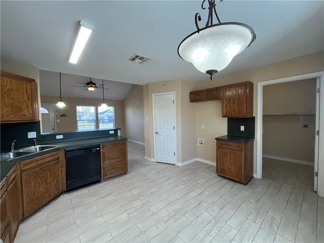 a kitchen with stainless steel appliances granite countertop a sink and wooden cabinets