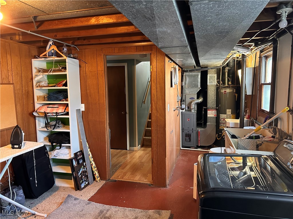 4034 Meister Road Lorain, OH 44053 - Photo 10 of 15 Below grade area with washer / clothes dryer, wooden walls, heating unit, stairs, and water heater