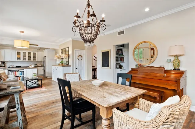 a view of a dining room with furniture a chandelier and wooden floor