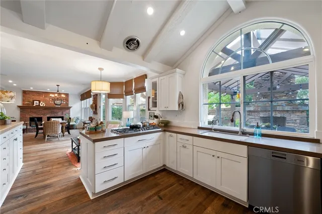 a kitchen with stainless steel appliances granite countertop a sink and cabinets with wooden floor