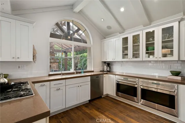 a kitchen with a stove a sink and a window