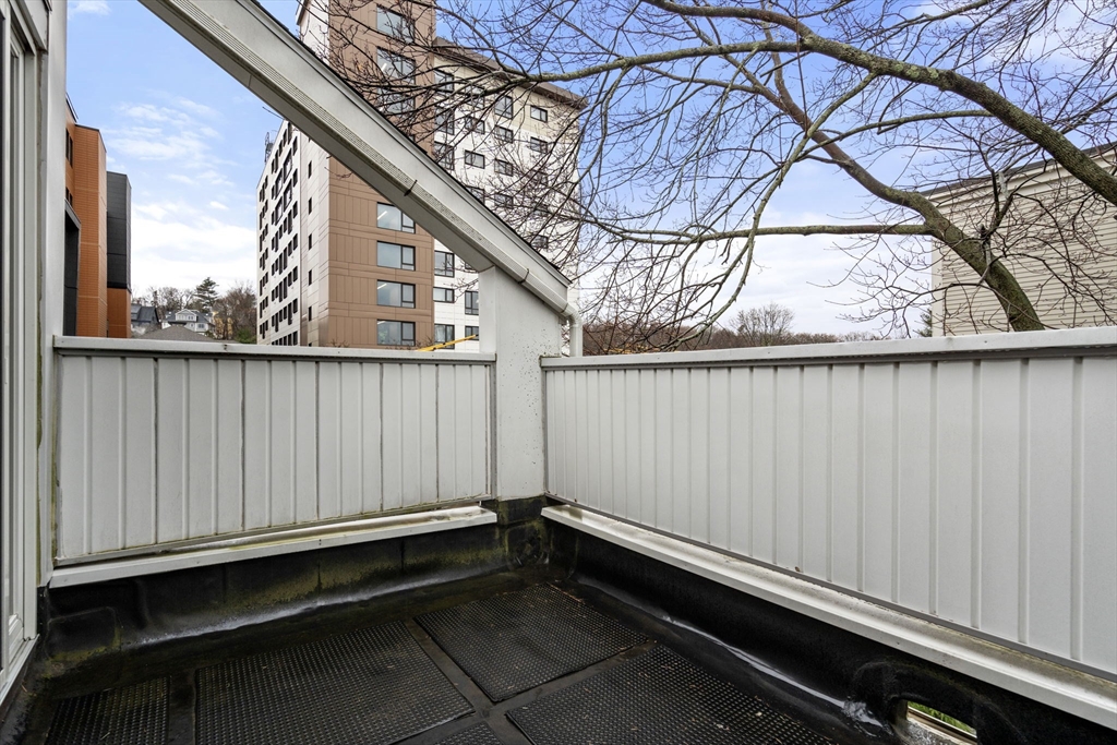 107 Centre Street, Unit A Brookline, MA 02446 - Photo 13 of 15 a view of a backyard with a barbeque and wooden fence