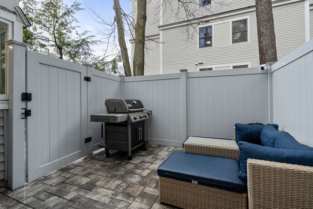 107 Centre Street, Unit A Brookline, MA 02446 - Photo 14 of 15 a backyard of a house with table and chairs
