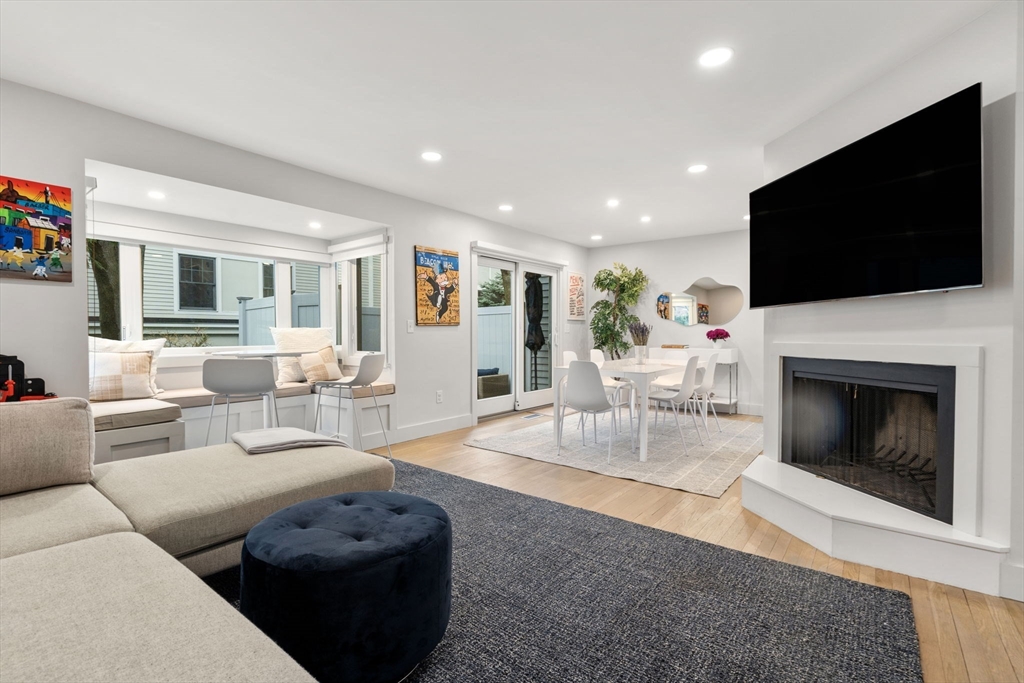 107 Centre Street, Unit A Brookline, MA 02446 - Photo 3 of 15 a living room with furniture a flat screen tv and a fireplace