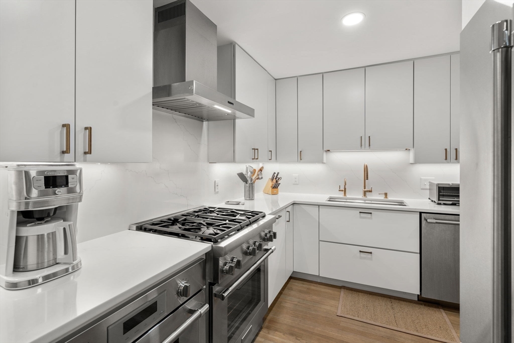 107 Centre Street, Unit A Brookline, MA 02446 - Photo 8 of 15 a kitchen with cabinets and stainless steel appliances