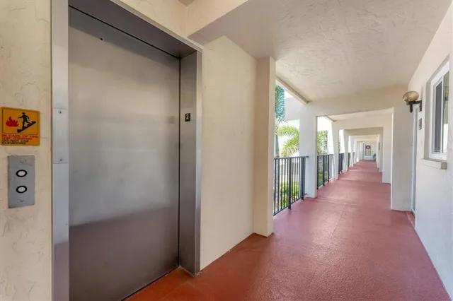 a living room with furniture and a large window with balcony view