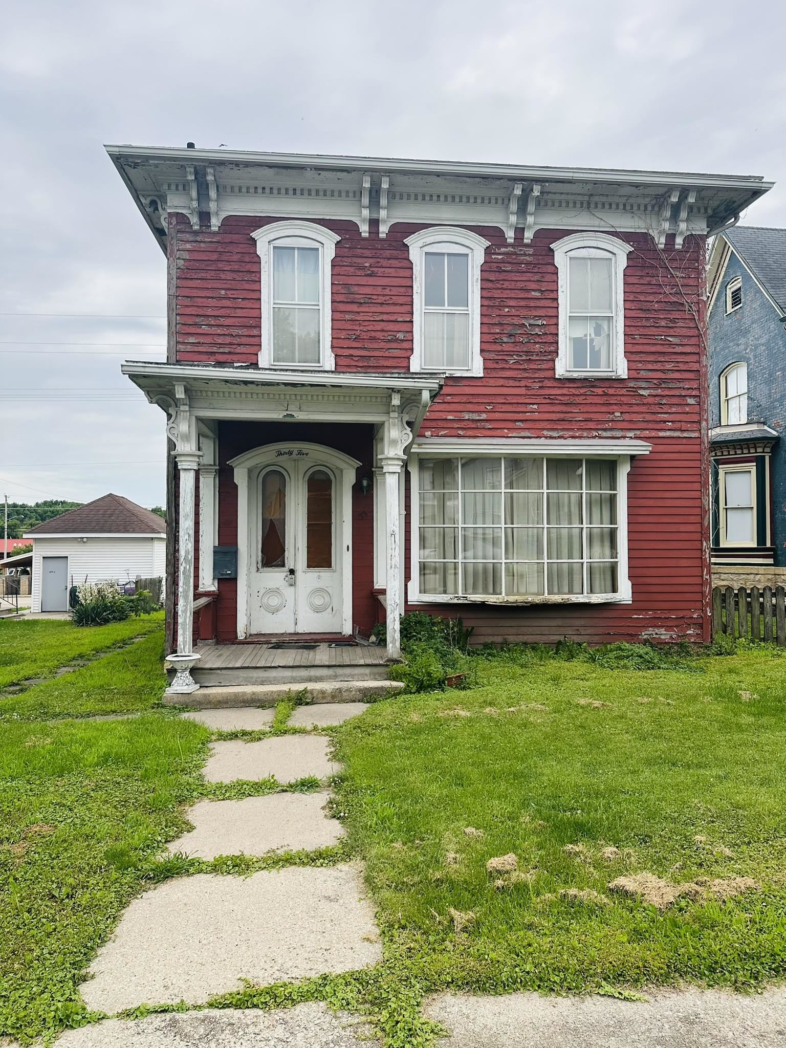 a front view of a house with a garden