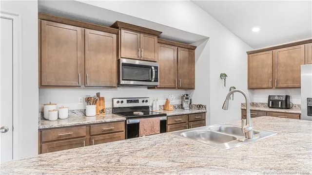 a view of a house with a big yard plants and large trees