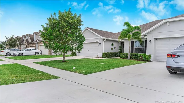 a view of a big house with a big yard and potted plants
