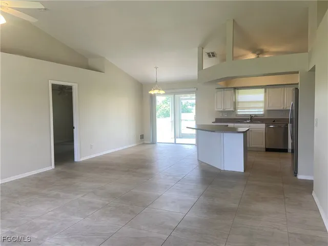 a large kitchen with stainless steel appliances granite countertop a stove top oven a sink dishwasher and a refrigerator