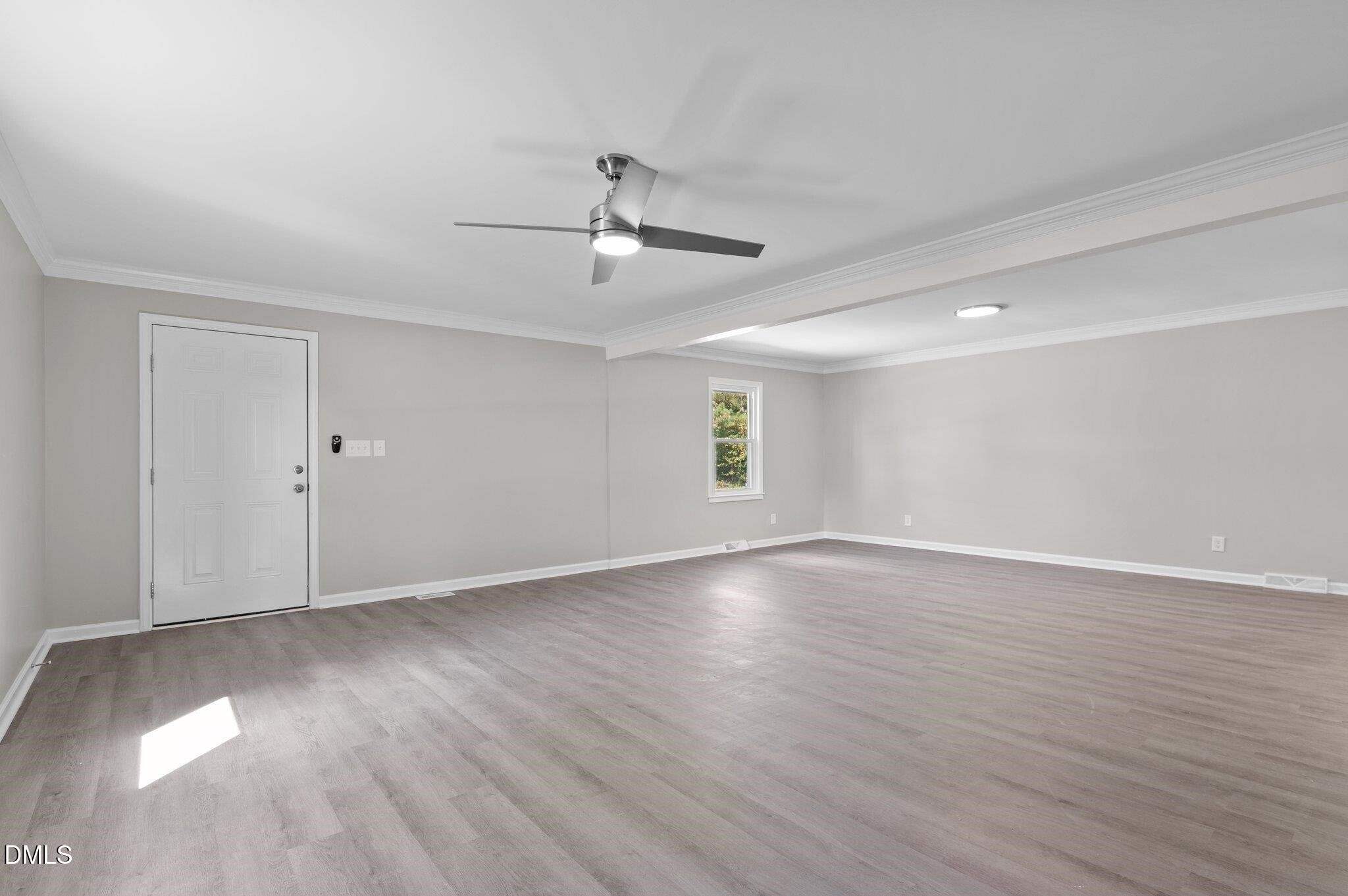 6501 Rock Service Station Road Raleigh, NC 27603 - Photo 26 of 49 a view of an empty room with wooden floor and a ceiling fan