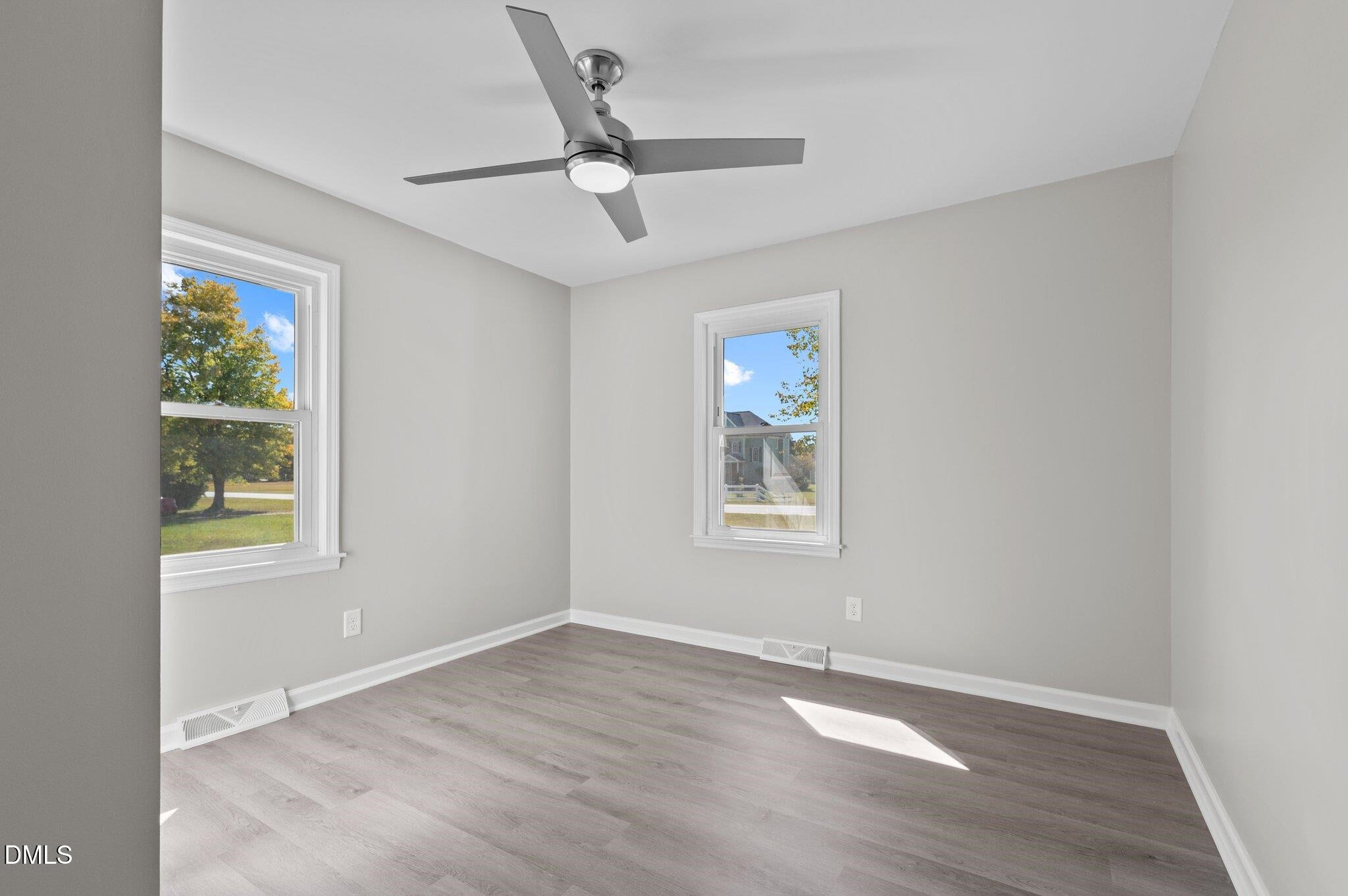 6501 Rock Service Station Road Raleigh, NC 27603 - Photo 41 of 49 an empty room with wooden floor chandelier fan and windows