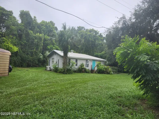 a view of a house with backyard and garden