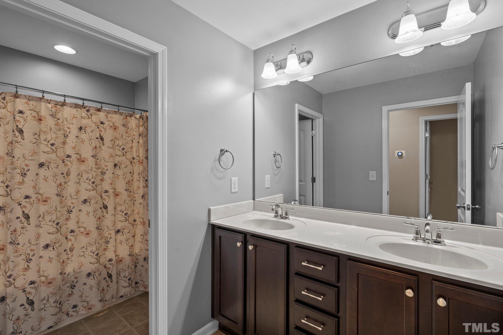 2421 Memory Ridge Drive Raleigh, NC 27606 - Photo 17 of 31 a bathroom with a double vanity sink mirror and shower