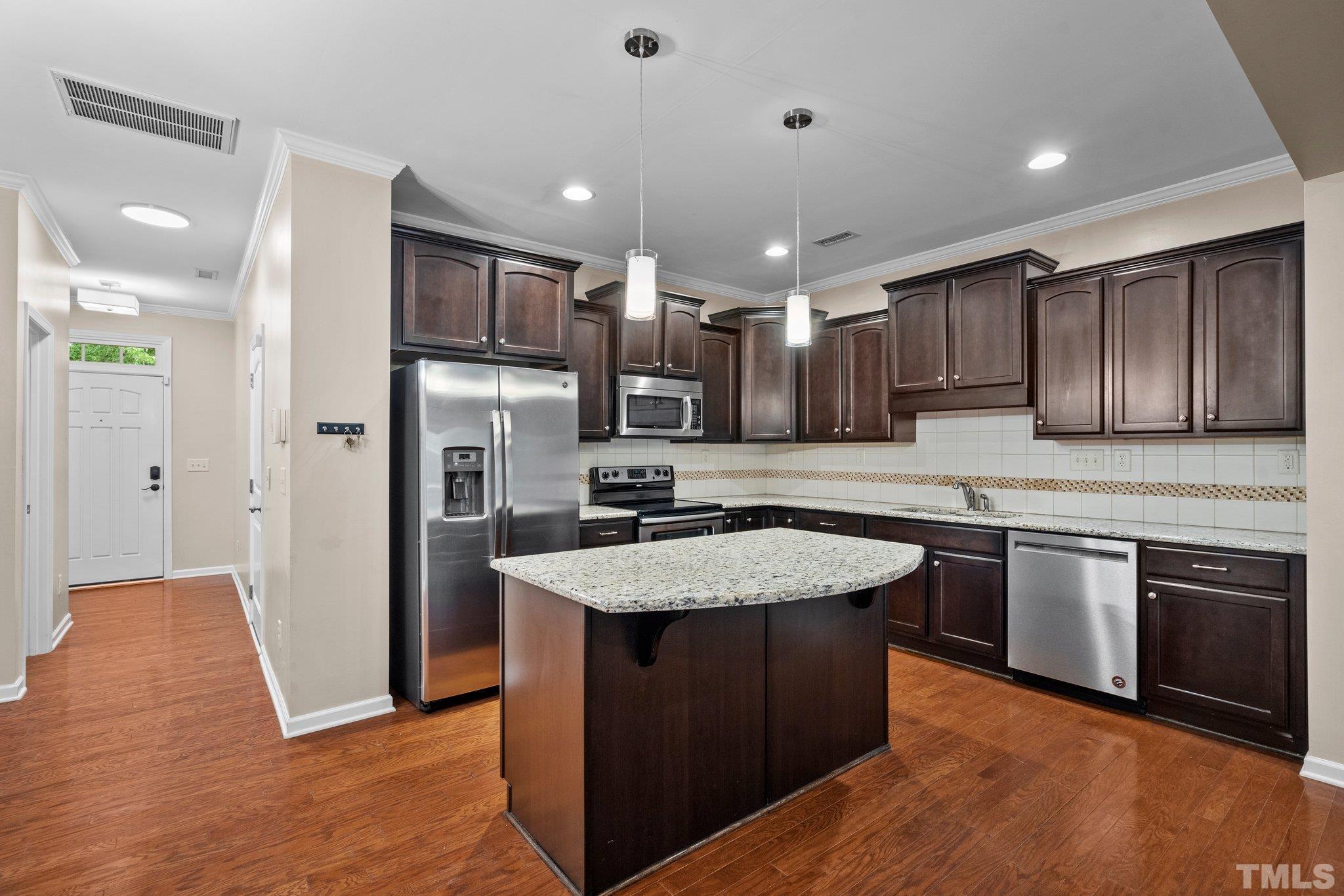 2421 Memory Ridge Drive Raleigh, NC 27606 - Photo 3 of 31 a kitchen with stainless steel appliances granite countertop a sink stove and refrigerator