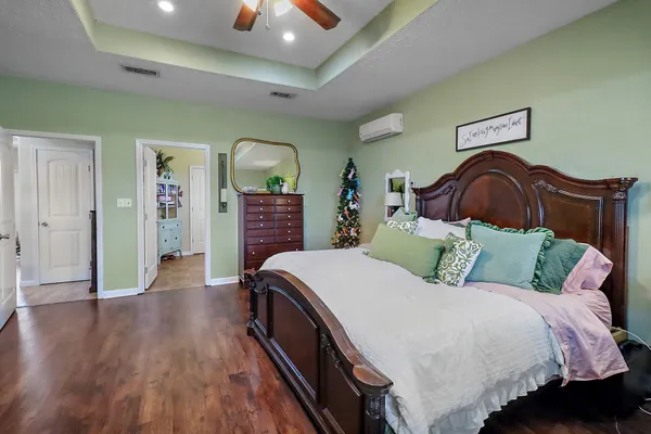 a spacious bedroom with a bed and wooden floor