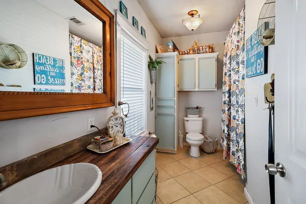 a bathroom with a sink a toilet and shower curtain