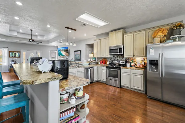 a kitchen with stainless steel appliances granite countertop a refrigerator stove microwave and sink