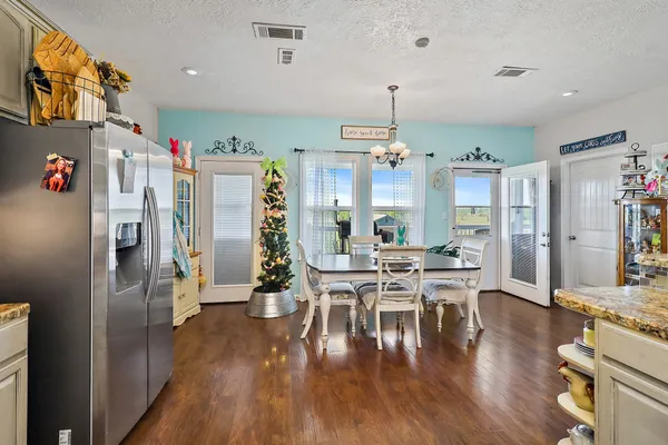a view of a dining room with furniture a rug and wooden floor