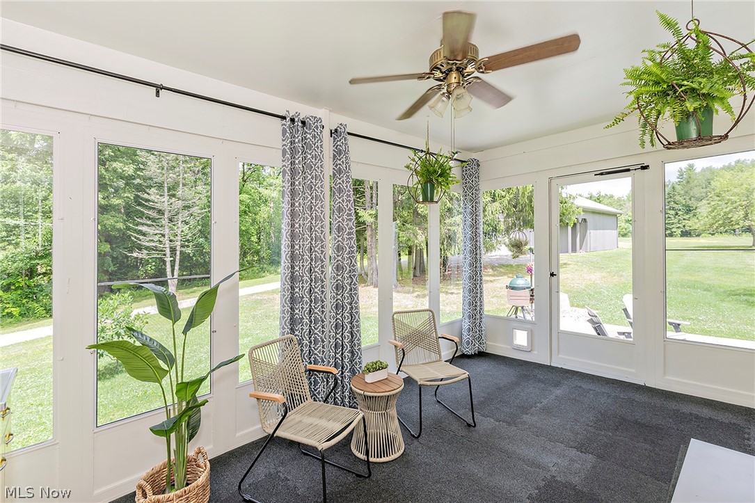 11292 Butternut Road Chardon, OH 44024 - Photo 21 of 49 Screened porch featuring large windows, dark flooring, white ceiling, and a ceiling fan