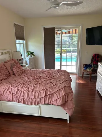 a bedroom with a bed and large windows