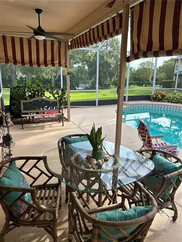 a view of a swimming pool with chairs in patio