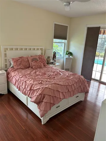 a bedroom with a bed lamp on desk and a window