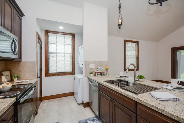 a kitchen with granite countertop a sink stove and cabinets