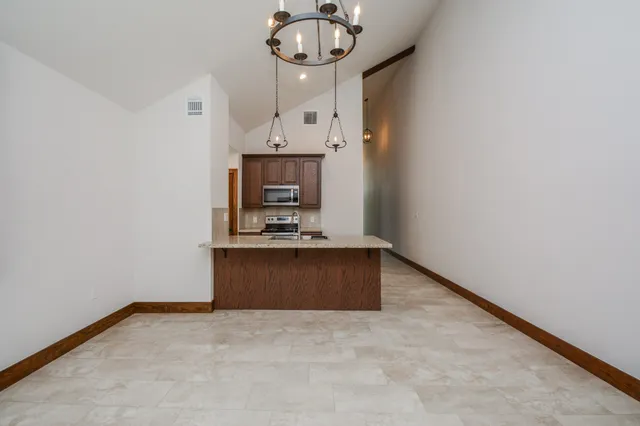 a view of an empty room with a fireplace and a window