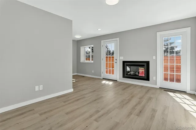 wooden floor fireplace and windows in an empty room