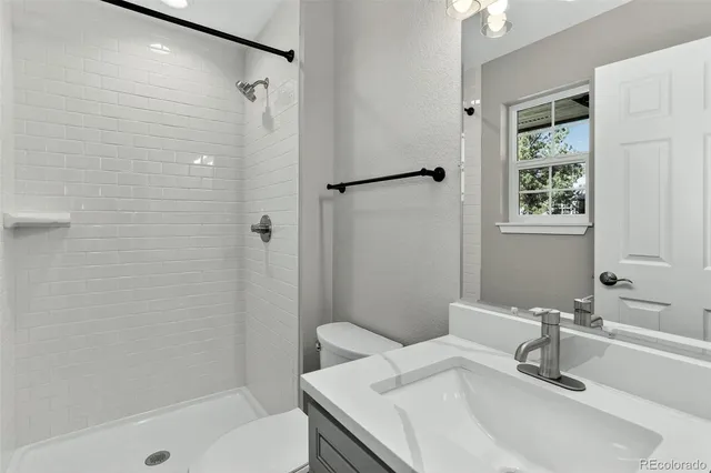a bathroom with a granite countertop sink toilet and shower