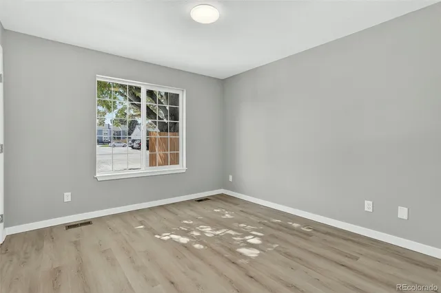 wooden floor in an empty room with a window