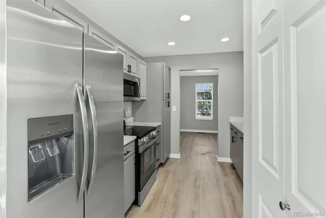 a kitchen with stainless steel appliances granite countertop a refrigerator and a sink