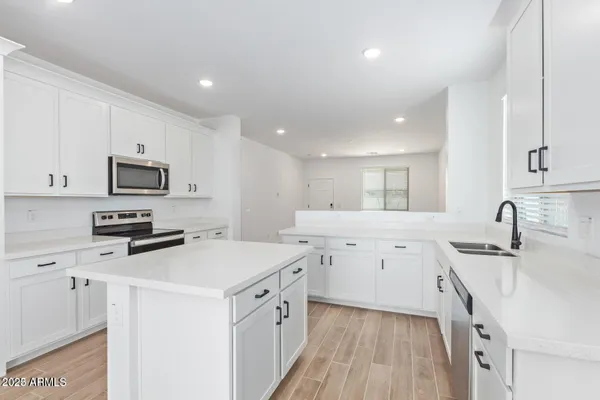 a kitchen with granite countertop a sink stove and refrigerator