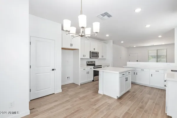 a large kitchen with cabinets wooden floor and stainless steel appliances