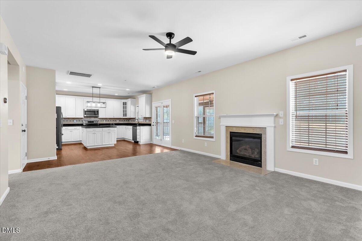 708 Straywhite Avenue Apex, NC 27539 - Photo 13 of 69 a view of empty room with kitchen view and a fireplace