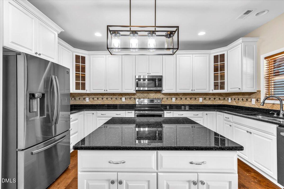 708 Straywhite Avenue Apex, NC 27539 - Photo 19 of 69 a kitchen with a sink a counter space stainless steel appliances and cabinets