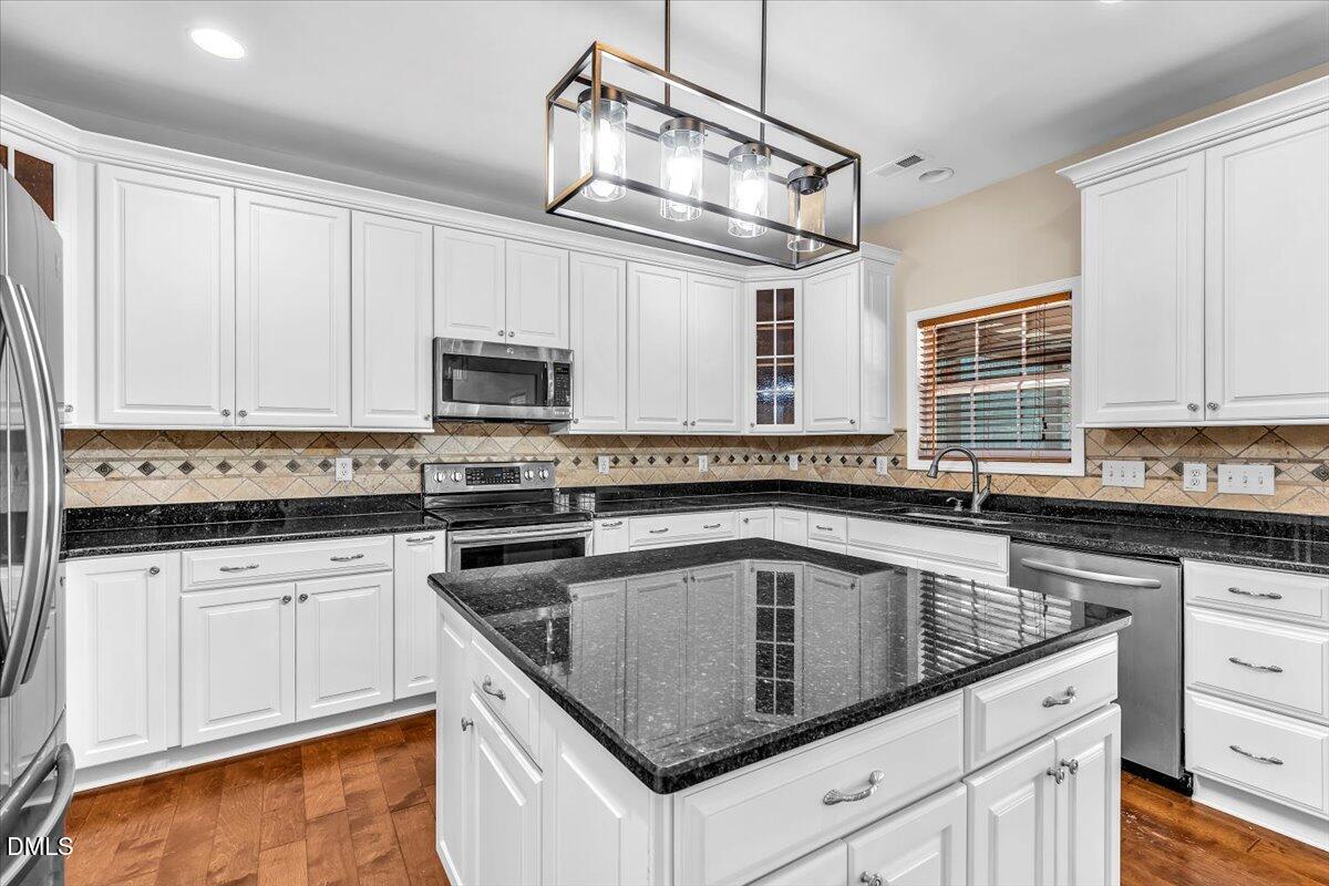 708 Straywhite Avenue Apex, NC 27539 - Photo 20 of 69 a kitchen with granite countertop white cabinets white stainless steel appliances and a sink