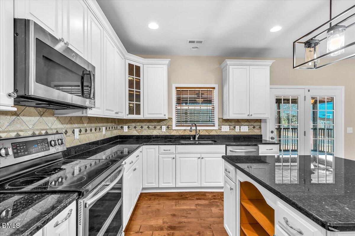 708 Straywhite Avenue Apex, NC 27539 - Photo 21 of 69 a kitchen with stainless steel appliances granite countertop a stove sink and cabinets
