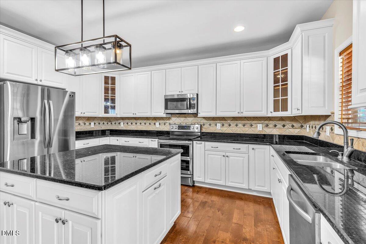708 Straywhite Avenue Apex, NC 27539 - Photo 23 of 69 a kitchen with granite countertop a sink stainless steel appliances and cabinets