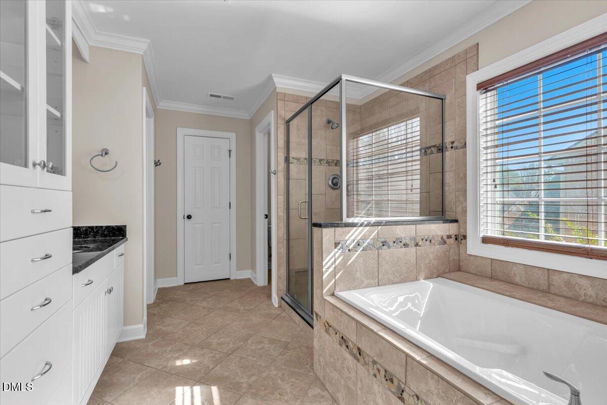 708 Straywhite Avenue Apex, NC 27539 - Photo 34 of 69 a spacious bathroom with a tub a double vanity sink a mirror and a shower