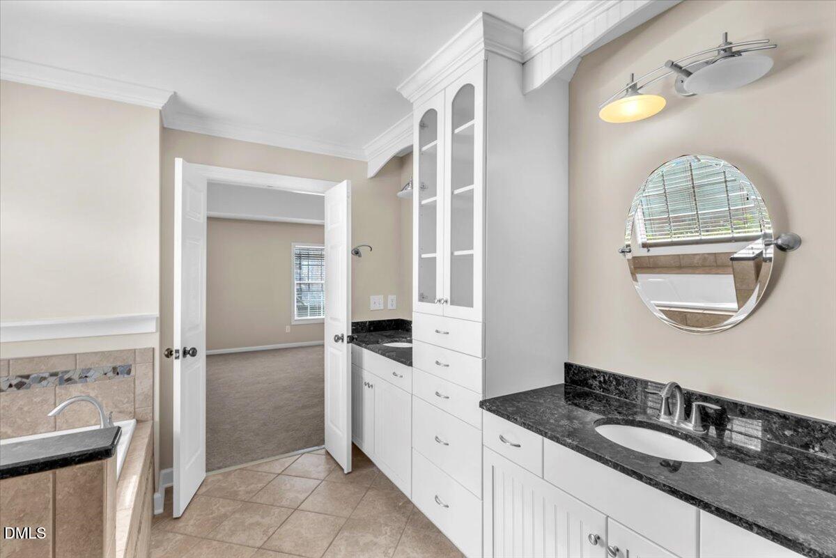 708 Straywhite Avenue Apex, NC 27539 - Photo 39 of 69 a bathroom with a granite countertop sink a mirror and a shower
