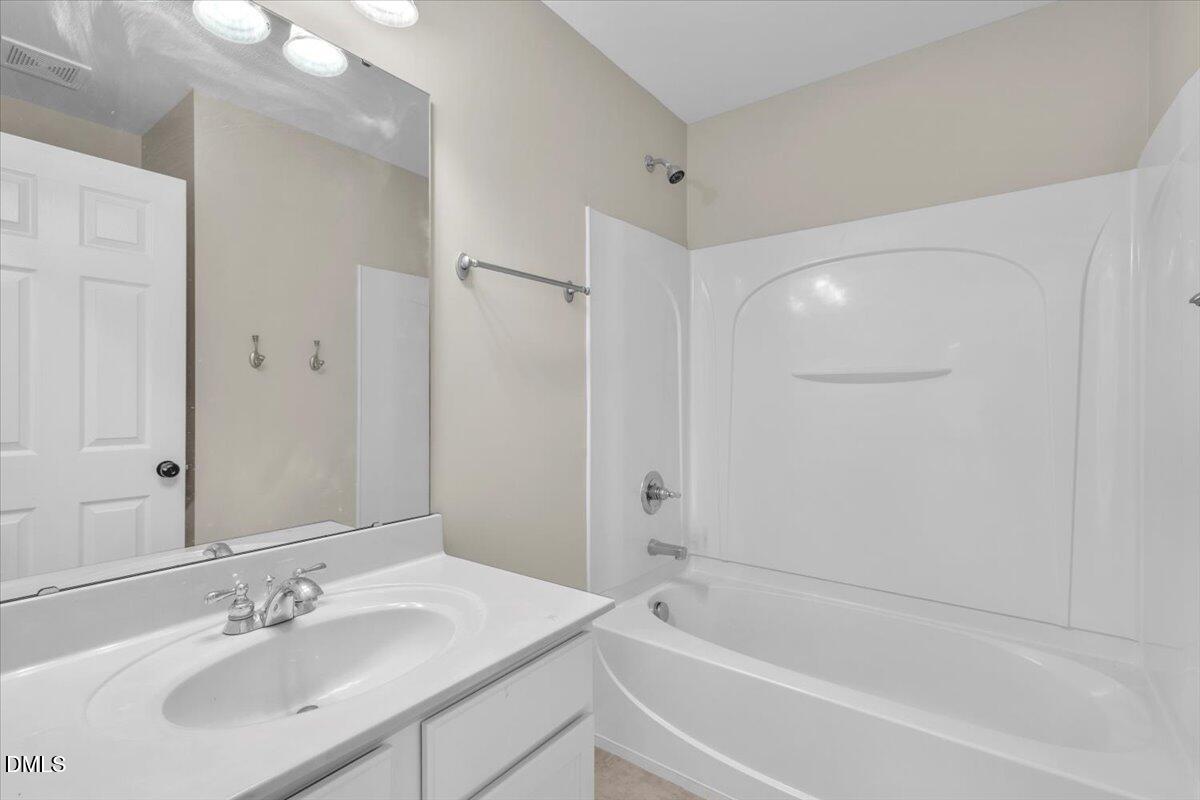 708 Straywhite Avenue Apex, NC 27539 - Photo 53 of 69 a bathroom with a bathtub shower sink and a mirror
