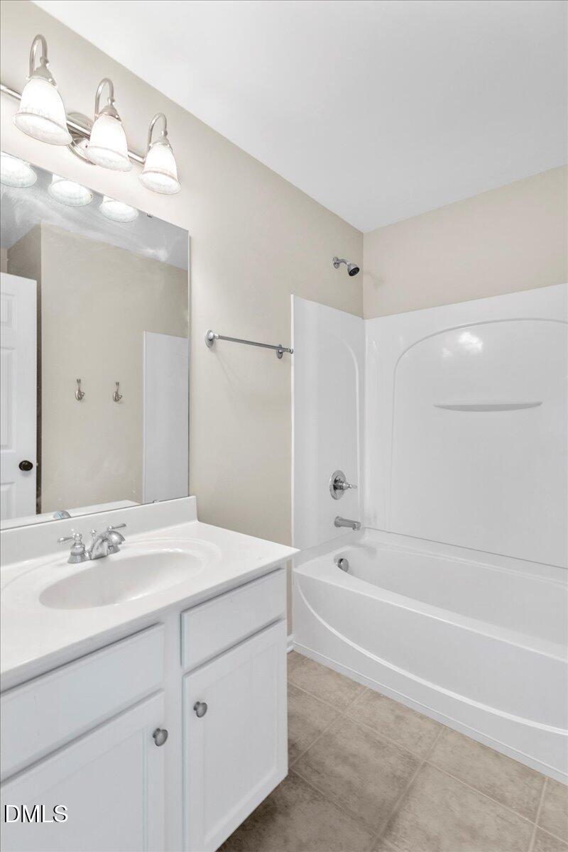 708 Straywhite Avenue Apex, NC 27539 - Photo 54 of 69 a bathroom with a bathtub a mirror a sink and vanity