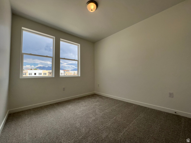 717 West W Coho Lane South, Unit 2F302 Midvale, UT 84047 - Photo 13 of 22 Bright interior space featuring two windows with surrounding white trim, neutral wall paint, and gray carpet flooring