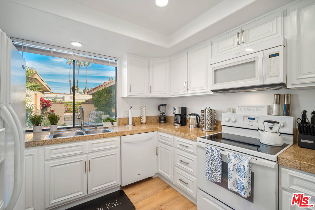 60 La Ronda Drive Rancho Mirage, CA 92270 - Photo 12 of 57 a kitchen with cabinets appliances a sink and a window
