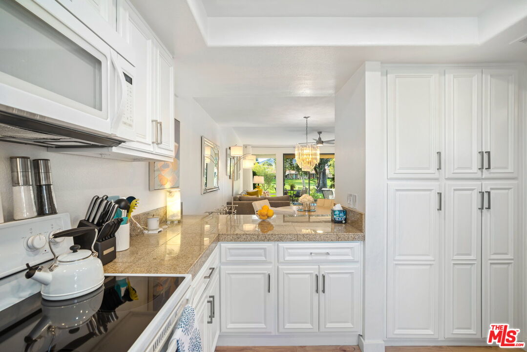 60 La Ronda Drive Rancho Mirage, CA 92270 - Photo 13 of 57 a kitchen with white cabinets and sink