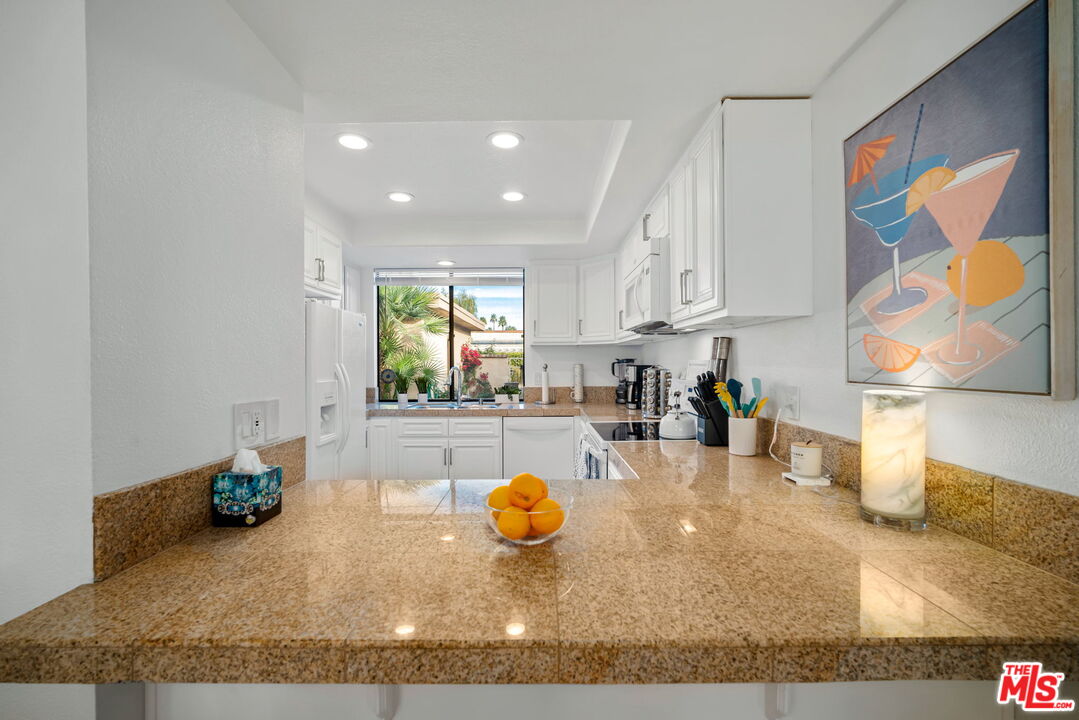 60 La Ronda Drive Rancho Mirage, CA 92270 - Photo 15 of 57 a kitchen with stainless steel appliances granite countertop a sink and a granite counter tops